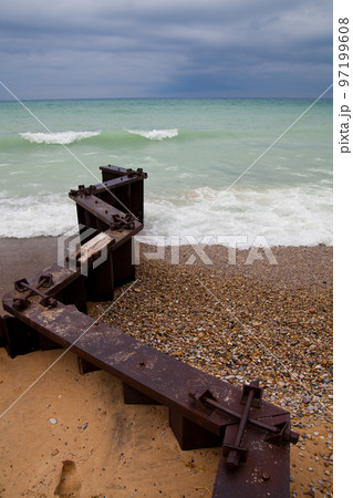 Zigzagging pier juts out into the lake and separates a rocky beach from a sandy beach Zigzagging pier juts out into the lake and separates a rocky beach from a sandy beach 97199608