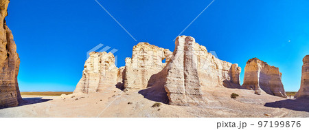 Panorama of white and beige vertical rock monuments against blue sky 97199876