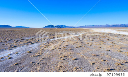Aerial of open desert landscape with mountains in distance 97199936
