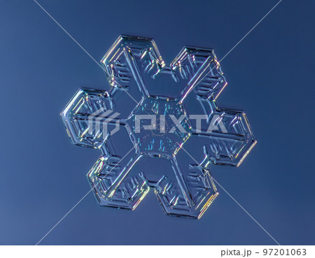 Snowflake on smooth gradient background. Macro photo of real snow crystal on glass surface. This is small snowflake crystal with unusual pattern 97201063