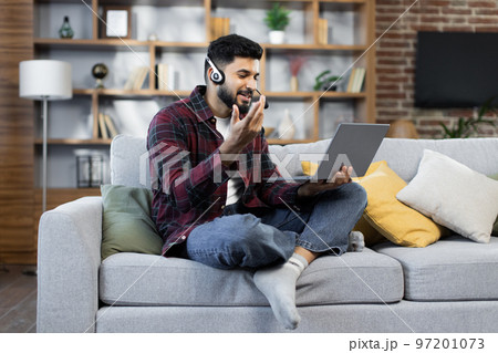Young bearded businessman working on computer, talking online using a headset Young bearded businessman working on computer, talking online using a headset 97201073