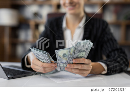 Selective focus on hands, young red hair caucasian woman with papers counting money at modern office Selective focus on hands, young red hair caucasian woman with papers counting money at modern office 97201334