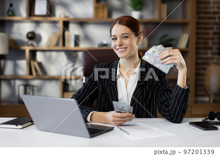 Accounting, taxes and finances concept - young red hair caucasian woman with papers counting money 97201339