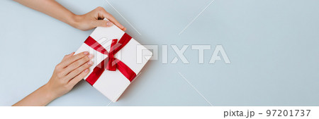 Banner women's hands hold a white with a red ribbon bow 97201737