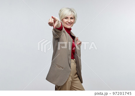 beautiful elderly woman with a smile points her finger at the camera. the concept of a business woman leader beautiful elderly woman with a smile points her finger at the camera. the concept of a business woman leader 97201745