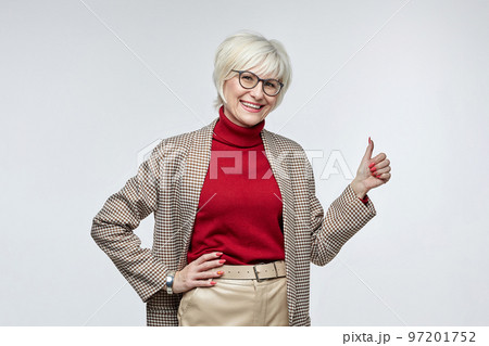 beautiful elderly woman with glasses gives a thumbs up. the concept of a business woman leader beautiful elderly woman with glasses gives a thumbs up. the concept of a business woman leader 97201752
