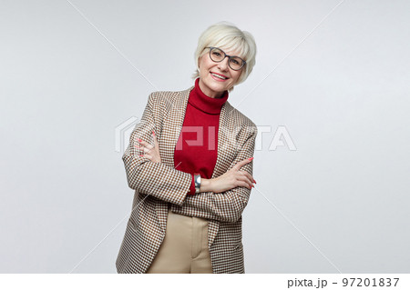 beautiful elderly woman with glasses poses in front of the camera in the studio on a white background. advertising concept of a business woman leader beautiful elderly woman with glasses poses in front of the camera in the studio on a white background. advertising concept of a business woman leader 97201837