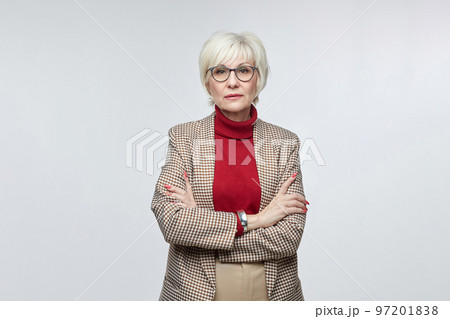 beautiful elderly woman with glasses poses in front of the camera in the studio on a white background. advertising concept of a business woman leader beautiful elderly woman with glasses poses in front of the camera in the studio on a white background. advertising concept of a business woman leader 97201838