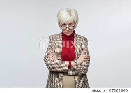 beautiful elderly woman with glasses poses in front of the camera in the studio on a white background. advertising concept of a business woman leader beautiful elderly woman with glasses poses in front of the camera in the studio on a white background. advertising concept of a business woman leader 97201840