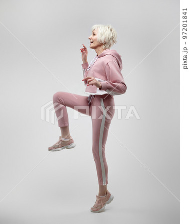 active elderly woman poses in the studio on a white background. fitness concept active elderly woman poses in the studio on a white background. fitness concept 97201841