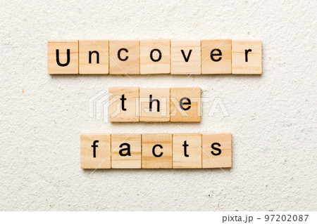 uncover the fact word written on wood block. uncover the fact text on table, concept 97202087