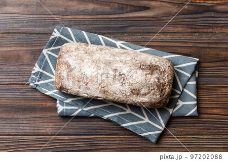 Fresh rye bread on napkin on rustic background, fresh bread top view Fresh rye bread on napkin on rustic background, fresh bread top view 97202088