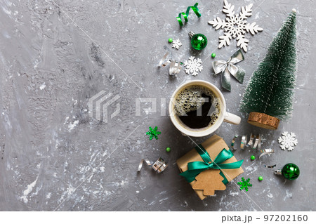 Delicious fresh festive morning coffee in a ceramic cup with little wrapped gifts, ornament and xmas toy. Cup of coffee and new year toys 97202160