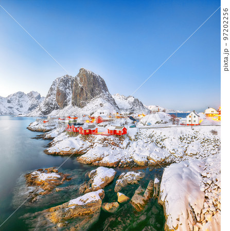 Outstanding sunset winter view on Hamnoy village and Festhaeltinden mountain on background. Outstanding sunset winter view on Hamnoy village and Festhaeltinden mountain on background. 97202256