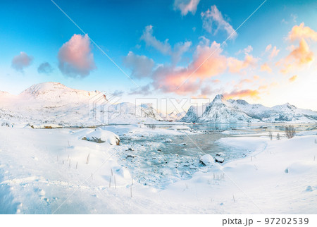 Fabulous frozen Flakstadpollen and Boosen fjords and reflection in water during sunrise with Hustinden mountain on background 97202539