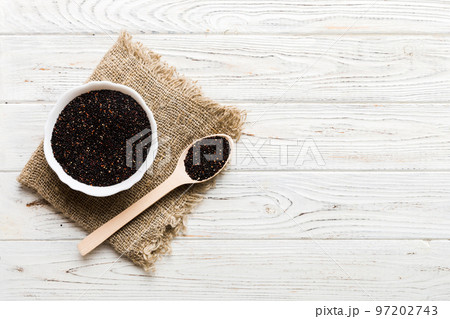 quinoa seeds in bowl and spoon on colored background. Healthy kinwa in small bowl. Healthy superfood 97202743