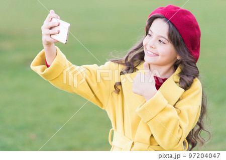 Best phone for taking selfie. Happy little girl make video call on mobile phone. Small child use phone camera for live streaming. Stay easily mobile and online with cell phone 97204047