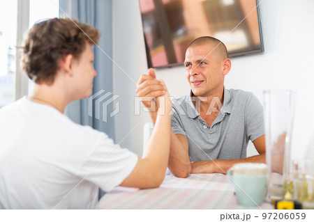 Son and his dad arm wrestling 97206059