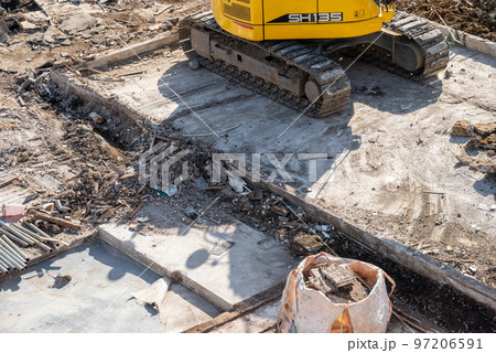 解体現場の重機と土間コンクリート 97206591