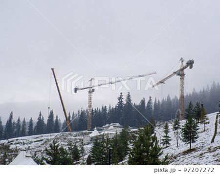 construction cranes among the mountains 97207272