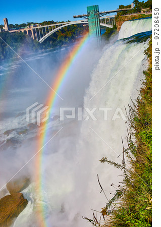 Misty American Falls and Rainbow Bridge with stunning rainbow at Niagara Falls 97208450