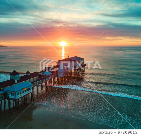 Golden sunrise over Maine ocean coast with old wood pier covered in shops Golden sunrise over Maine ocean coast with old wood pier covered in shops 97209015