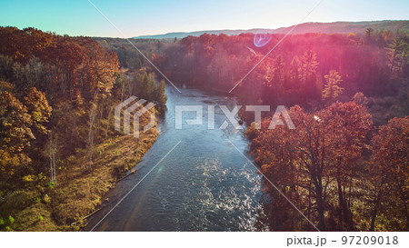 Aerial solar flare over Michigan river during late fall with warm colors 97209018