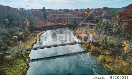 Late fall vibes aerial at suspension bridge over river in Michigan  97209051