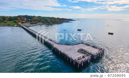 Aerial over large walking pier for tourists attached to Maine coast Aerial over large walking pier for tourists attached to Maine coast 97209095