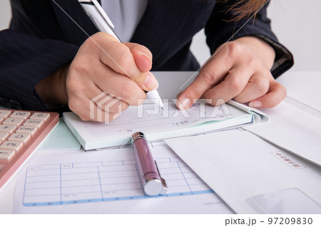 領収書を書くスーツの女性 97209830