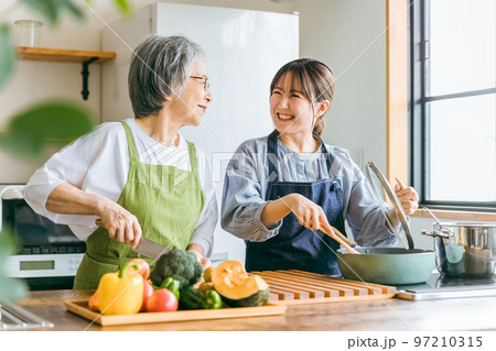 家のキッチンで一緒に料理・家事・自炊をする笑顔のアジア人高齢者女性と若い女性(家政婦・家事代行) 家のキッチンで一緒に料理・家事・自炊をする笑顔のアジア人高齢者女性と若い女性(家政婦・家事代行) 97210315