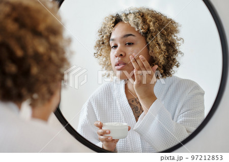 Young attractive woman applying moisturizing cream on face 97212853