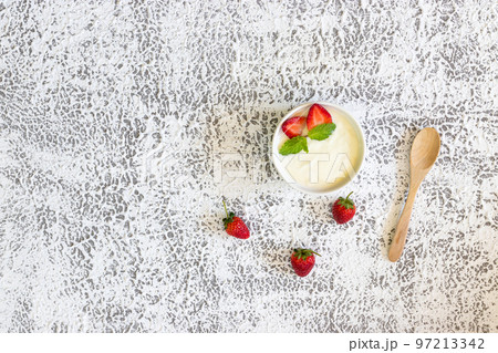 Top view of Strawberry yogurt in a wooden bowl with granola,  mint and fresh strawberry on wooden background. Health food concept.. 97213342