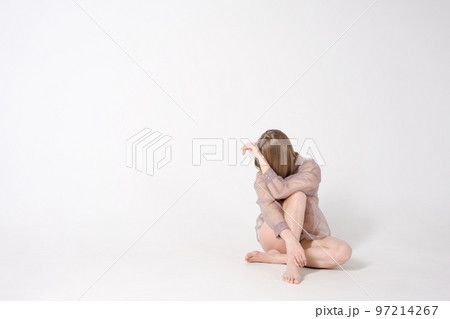 Woman is sitting on light background in studio. She is sad and depressed 97214267