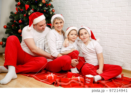 Portrait of happy family with Christmas gifts on floor. Cheerful family Portrait of happy family with Christmas gifts on floor. Cheerful family 97214941