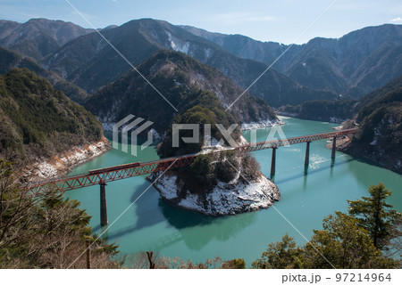 静岡県榛原郡川根本町にある大井川鐡道の奥大井湖上駅の奥大井レインボーブリッジと積雪と水面と車両 97214964