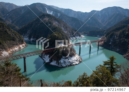 静岡県榛原郡川根本町にある大井川鐡道の奥大井湖上駅の奥大井レインボーブリッジと積雪と水面と車両 97214967