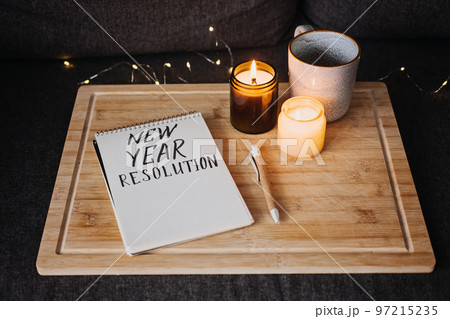 Goals for the 2023 year, New year resolution Text in open notepad near cup and candles at sofa in home. Start new life, planning and setting goals 97215235