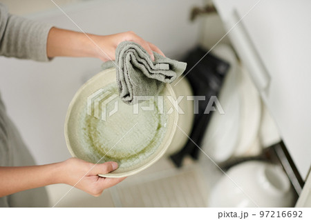 Hands of woman wiping plates with soft towel Hands of woman wiping plates with soft towel 97216692
