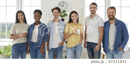 Group portrait of happy smiling mixed race friends standing and looking at camera in living room. Group portrait of happy smiling mixed race friends standing and looking at camera in living room. 97221641