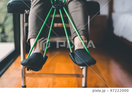 Elderly woman doing exercises and stretching for treatment with a rubber resistance bands 97222000
