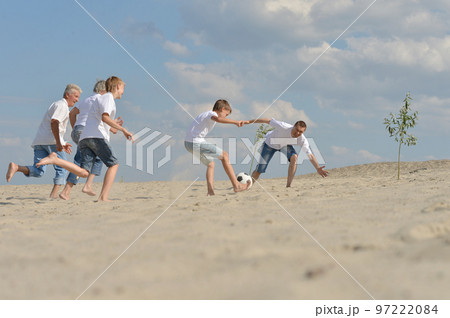 Family playing football on a beach in summer day Family playing football on a beach in summer day 97222084