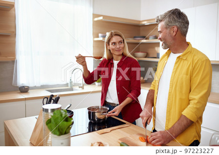 Couple Cooking At Kitchen. Senior Positive Man Cutting Vegetables For Salad Couple Cooking At Kitchen. Senior Positive Man Cutting Vegetables For Salad 97223227