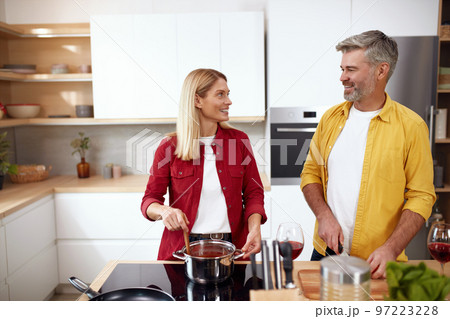 Couple Cooking At Kitchen. Senior Positive Man Cutting Vegetables For Salad Couple Cooking At Kitchen. Senior Positive Man Cutting Vegetables For Salad 97223228