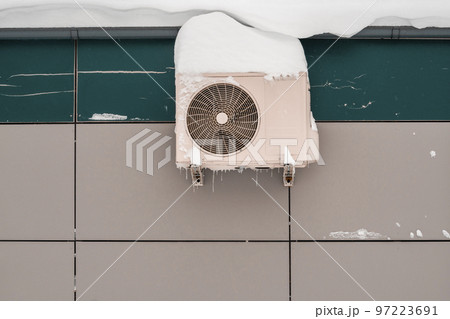 An outdoor air conditioner unit installed on the outer wall of a building An outdoor air conditioner unit installed on the outer wall of a building 97223691