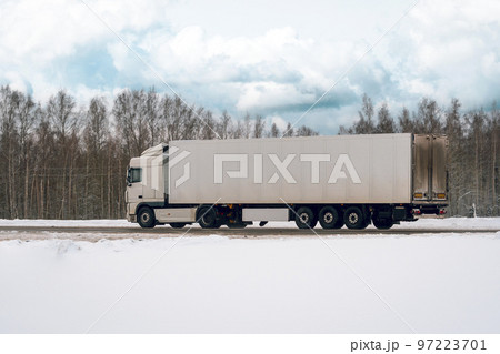 Truck driving on the winter road in rural landscape Truck driving on the winter road in rural landscape 97223701