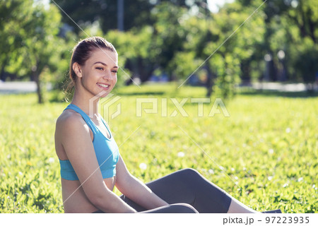 Beautiful smiling girl in sportswear relax in park Beautiful smiling girl in sportswear relax in park 97223935