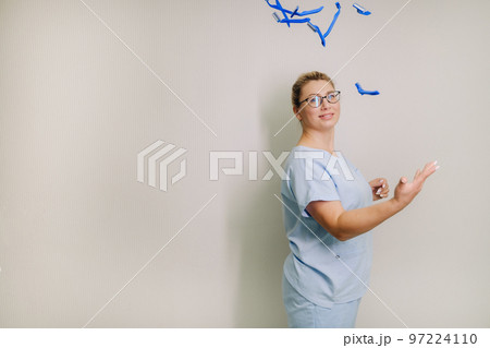a female laser hair removal master in a blue robe throws shaving machines on a light background a female laser hair removal master in a blue robe throws shaving machines on a light background 97224110