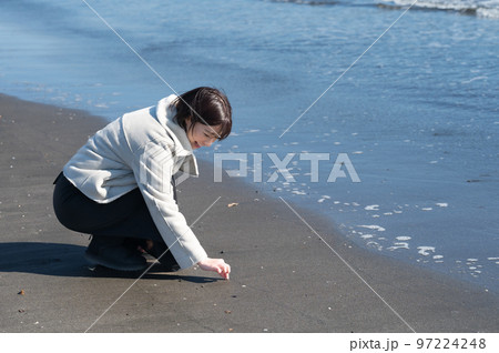 冬の砂浜で遊ぶ女性 97224248