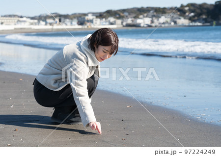 冬の砂浜で遊ぶ女性 97224249